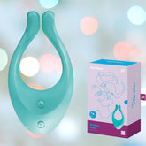 The image showcases a teal Satisfyer 'Endless Love' Couples Multi-Use Vibrator made from body-friendly silicone, resting next to its packaging box. The unique U-shaped design features two buttons and offers 100 vibration combinations. A soft bokeh effect background in pastel blue, pink, and white creates a dreamy look.